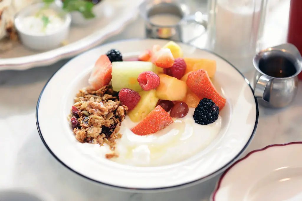 Bowl de yogur griego con granola y frutas + exprimido